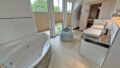 Badezimmer mit Eckbadewanne und Sauna